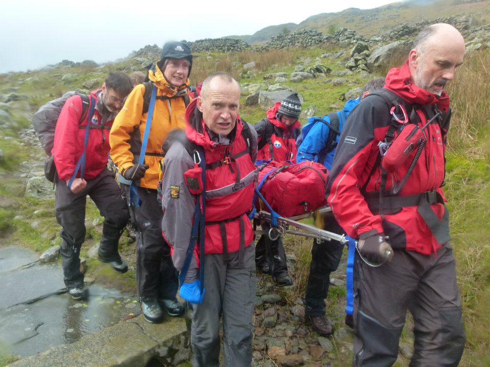 Wet team members carry stretcher