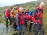 Wet team members carry stretcher